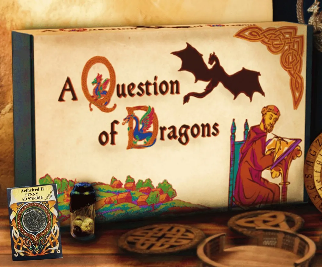A Question of Dragons — the case-file box beside the replica penny card, the sealed reliquary vial and a stack of Celtic knot coasters
