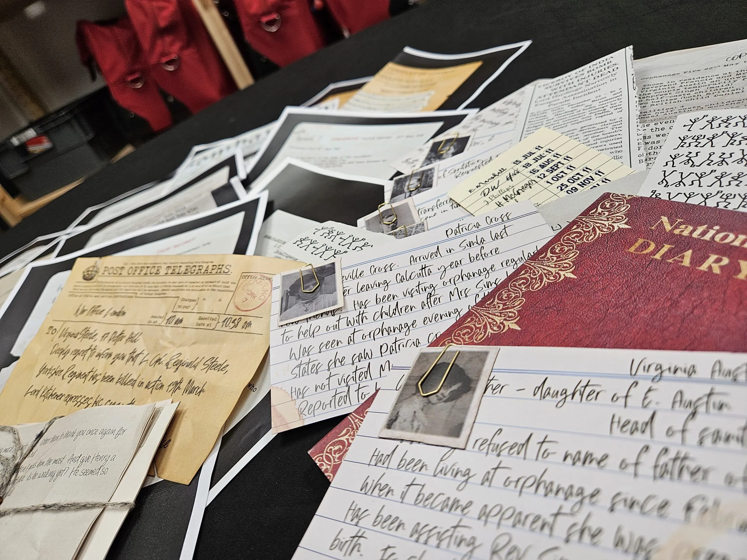 The Virginia Steele case file laid out on a desk — a leather-bound notebook, period photographs and the orphanage paperwork